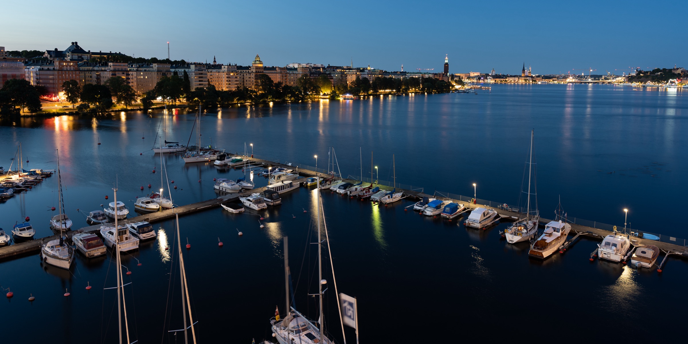 Stockholm waterfront and marina at blue hour, city lights reflecting in the water